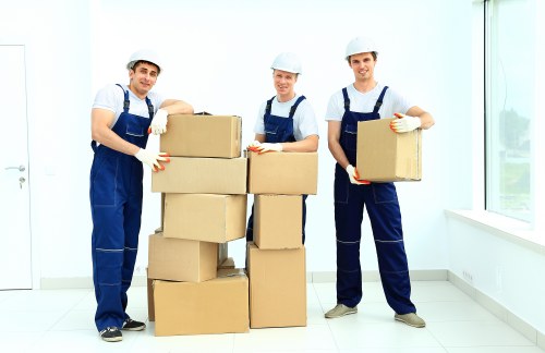 Collection team handling sofas, beds, and tables in a West Kensington property